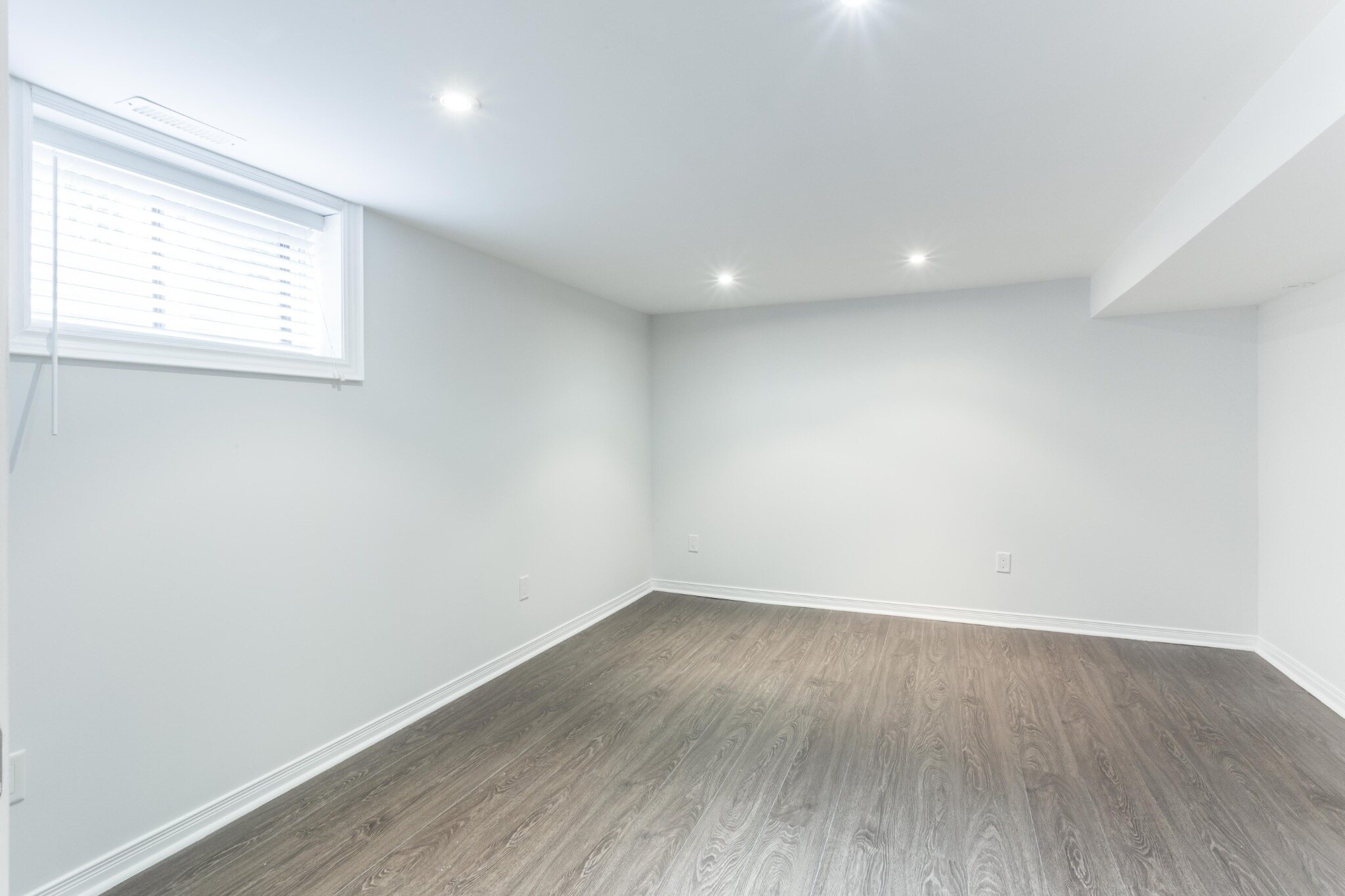 First bedroom with recessed lighting and window